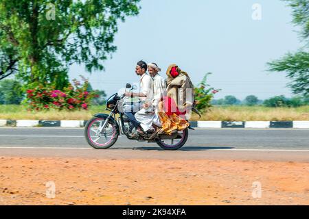 RAJASTHAN - INDIA - 18 OTTOBRE: Madre, padre e bambino piccolo che cavalca scooter attraverso strada trafficata di autostrada il 18 ottobre 2012 in Rajasthan, India. Su Foto Stock