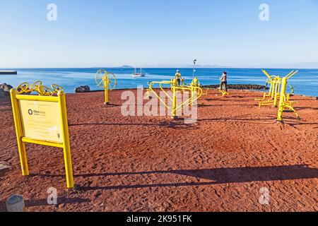 PLAYA BLANCA, SPAGNA - 29 MARZO: La gente si allinea alla stazione di fitness all'aperto il 29 marzo 2013 a Playa Blanca, Spagna. Il centro fitness è stato inaugurato nel 2009 Foto Stock