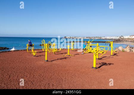 PLAYA BLANCA, SPAGNA - 29 MARZO: La gente si allinea alla stazione di fitness all'aperto il 29 marzo 2013 a Playa Blanca, Spagna. Il centro fitness è stato inaugurato nel 2009 Foto Stock