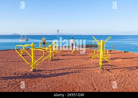 PLAYA BLANCA, SPAGNA - 29 MARZO: La gente si allinea alla stazione di fitness all'aperto il 29 marzo 2013 a Playa Blanca, Spagna. Il centro fitness è stato inaugurato nel 2009 Foto Stock