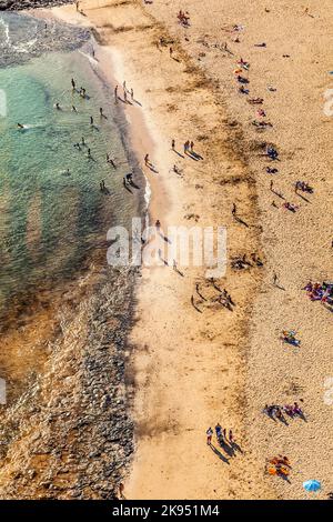 ARRECIFE, SPAGNA - 8 APRILE: spiaggia con i turisti in estate il 8,2012 aprile a Arrecife, Spagna. La spiaggia El Reducto è riconosciuta dall'Europa come bandiera blu Foto Stock