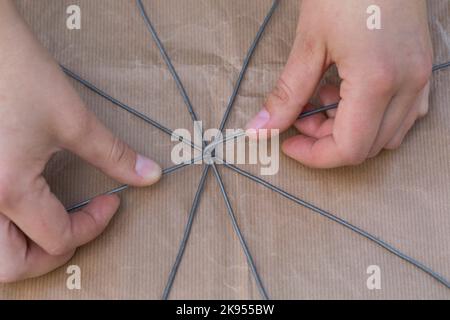 realizzazione di un dispenser per il nesting di materiale per uccelli o scoiattoli, fase 2: star ist costruito con fili, serie foto 2/5 Foto Stock