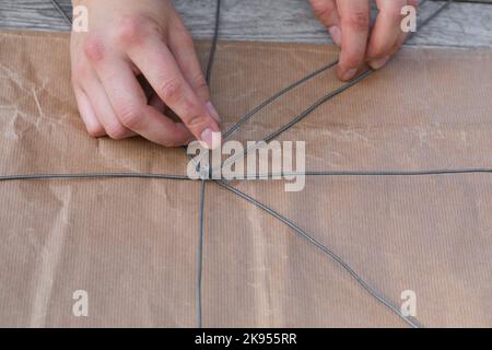 realizzazione di un dispenser per il nesting di materiale per uccelli o scoiattoli, fase 2: star ist costruito con fili, serie foto 2/5 Foto Stock