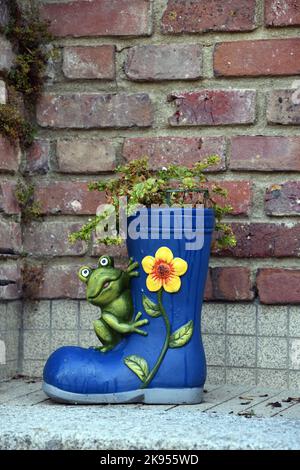 Decorazione giardino, rana seduta su uno stivale di gomma blu piantato, Francia, Normandia, Dipartimento Seine-Maritime , Neufchatel-en-Bray Foto Stock