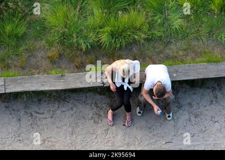 Coppia seduta su una panca di legno sul lato della strada facendo una pausa, foto aerea, Belgio, Anversa, Kalmthout, Kalmthoutse Heide Foto Stock