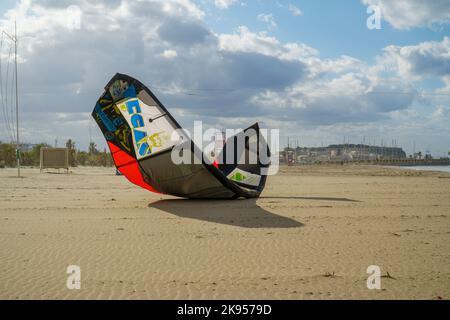 Il paracadute di kiteboarding sulla sabbia sullo sfondo del cielo azzurro nuvoloso. Foto Stock