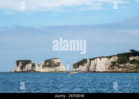 All'ancora in Studland Bay, Dorset Inghilterra, Regno Unito, con le rocce di Harry grandi oltre. Foto Stock