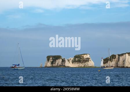 All'ancora in Studland Bay, Dorset Inghilterra, Regno Unito, con le rocce di Harry grandi oltre. Foto Stock