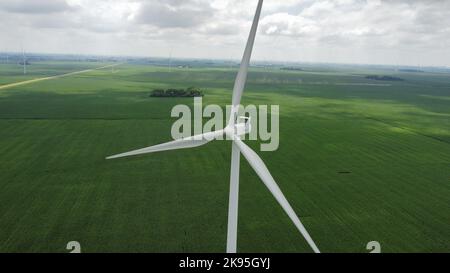 Un colpo aereo delle turbine eoliche in primo piano in una giornata nuvolosa Foto Stock