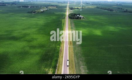 Un'immagine aerea del primo piano verde con turbine eoliche in una giornata nuvolosa Foto Stock