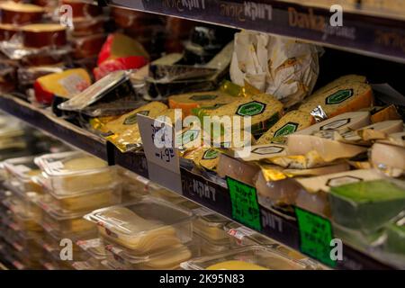 Un primo piano di vari tipi di formaggio con i prezzi nel mercato Carmel Foto Stock