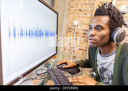 L'Agenzia dei media: Modifica delle forme d'onda. Un ingegnere audio al lavoro in uno studio di registrazione - forma d'onda generica sullo schermo. Da una serie di immagini correlate. Foto Stock