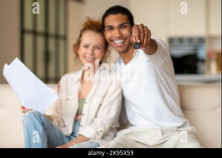 I giovani che si guardano felici dopo aver firmato un contratto per un nuovo contratto di affitto Foto Stock