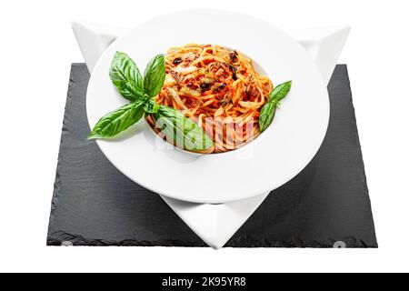 Spaghetti tonno pasta basilico piatto triangolare forma ardesia tavolo piuttosto appetitoso Foto Stock
