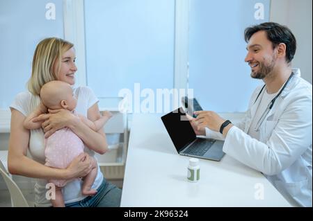 Medico pediatrico esperto che consulta un genitore di sesso femminile Foto Stock