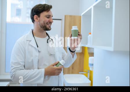 Operatore sanitario che controlla la data di scadenza dei supplementi dietetici Foto Stock