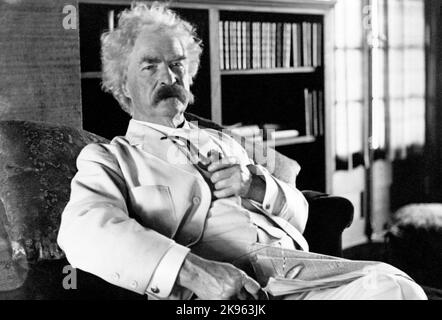 Mark Twain (Samuel L. Clemens) ritratto di tre quarti di lunghezza, seduto, rivolto leggermente a destra, tenendo tubo Foto Stock