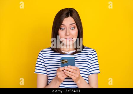 Foto di abbastanza grave braccio donna tenere telefono scrivere ottenere prova distanza studio lavoro remoto isolato su sfondo giallo colore Foto Stock