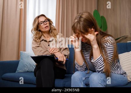 La ragazza sconvolta piange ad una sessione con uno psicologo Foto Stock