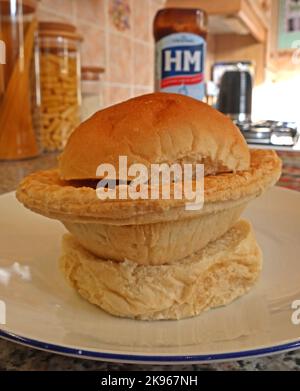 Wigan Lancashire Pie Burger, una bistecca o una torta di carne su un muffin fondo forno, con bottiglia di salsa HP - Northern North West British comfort food, Regno Unito Foto Stock