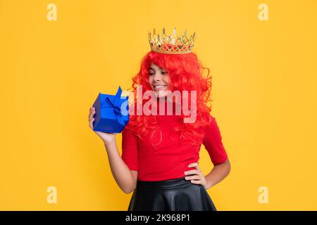 bambino allegro in diadem con scatola presente su sfondo giallo Foto Stock