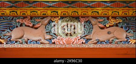 Legno intagliato simbolo del primo sermone del Buddha nel parco dei cervi di Sarnath con cervi e dharmachakra o ruota dharma a Punakha dzong, Bhutan Foto Stock