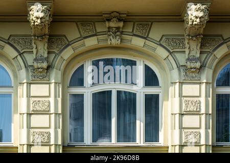 Finestra ad arco con una scultura a cornice bianca e stucco riflesso di alberi contro una parete luminosa. Dalla serie Window of the World. Foto Stock