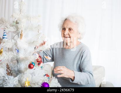 Donna anziana decorazione albero di natale Foto Stock