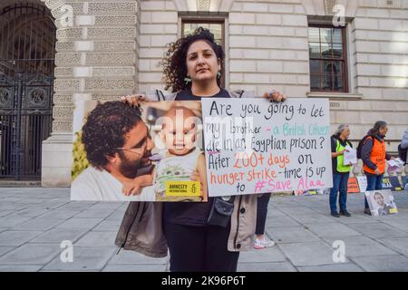 Londra, Regno Unito. 26th ottobre 2022. Sanaa Seif ha una foto di suo fratello al di fuori dell'Ufficio degli Esteri, del Commonwealth e dello sviluppo. Sanaa Seif, la sorella di Alaa Abdel Fattah, un attivista britannico-egiziano incarcerato in Egitto, che è stato in sciopero della fame per oltre 200 giorni, ha organizzato un sit-in al di fuori dell'ufficio degli esteri di Westminster. Ha dormito in una tenda all'aperto e continuerà a farlo fino all'inizio del COP 27 o fino a quando il Ministro degli esteri James non accetterà abilmente di incontrarla e intensificherà gli sforzi per il suo rilascio. Credit: Vuk Valcic/Alamy Live News Foto Stock