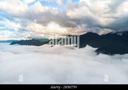 Vista maestosa delle montagne tra le nuvole. Montagne tra le nuvole. Nuvole alte e basse. Bellissimo paesaggio alpino naturale. Foto Stock