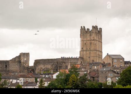 Richmond, North Yorkshire, Regno Unito - 13 giugno 2009: Il castello di Richmond con un aereo militare che vola sopra di esso. Gli spettatori fieggiano le pareti del Foto Stock