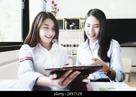 Un consulente di affari femminile descrive un programma di vendita per regolare le strategie di affari per i proprietari di affari delle donne. Foto Stock