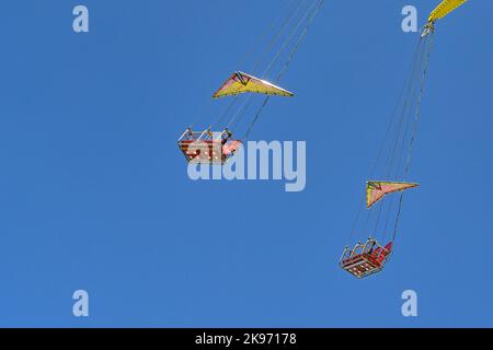 Posti a sedere vuoti su un alto giro in giostra oscillante in una zona fieristica. Nessuna gente. Foto Stock