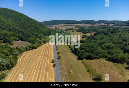 landscape with a road through a rural area in Romania Foto Stock