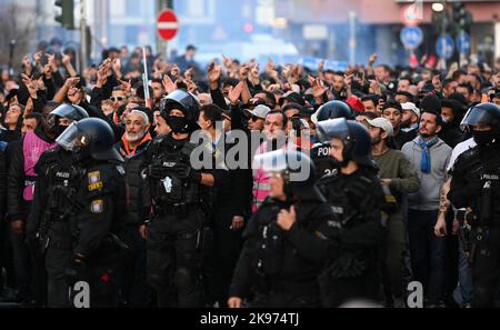 26 ottobre 2022, Hesse, Francoforte sul meno: Gli agenti di polizia accompagnano i tifosi dell'Olympique Marseille durante la loro marcia da Römerberg alla stazione ferroviaria principale. In serata, le squadre di calcio dell'Eintracht Frankfurt e dell'Olympique Marseille giocano l'una contro l'altra nella Champions League. Foto: Arne Dedert/dpa Foto Stock