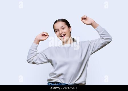 Allegra ragazza adolescente danzante su sfondo bianco studio Foto Stock