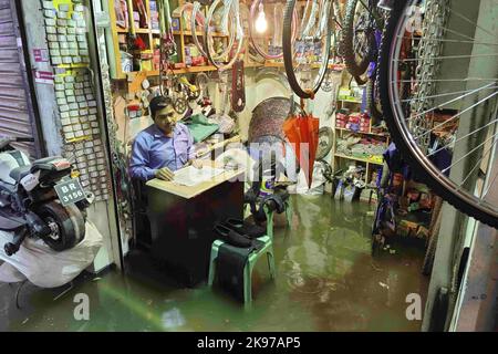 Dhaka, Bangladesh. 24th Ott 2022. Un negoziante si siede all'interno del suo negozio allagato dopo la forte pioggia causata dal ciclone Sitrang a Dhaka, Bangladesh, 24 ottobre 2022. Secondo l'autorità per il trasporto delle acque interne del Bangladesh (BIWTA) e il Dipartimento di Meteorologia del Bangladesh, il trasporto delle acque interne è stato sospeso in quanto il ciclone Sitrang, in avvicinamento, dovrebbe attraversare la parte sud-sud-ovest del distretto di Barishal e Chittagong entro il 25 ottobre. (Credit Image: © Suvra Kanti Das/ZUMA Press Wire) Foto Stock