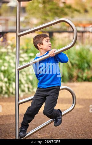 Mayfield Park Manchester, bambino che gioca sul telaio di arrampicata Foto Stock