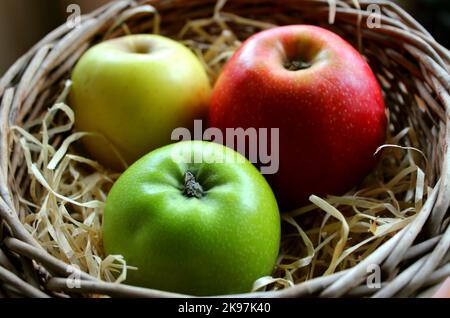 Gala Apple, Granny Smith Apple e Golden Delicious Apple si trovano fianco a fianco in Un cestino di vimini Foto Stock