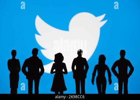 Le silhouette figurate della gente sono viste davanti al logo sfocato di Twitter in esposizione. Concetto. Stafford, Regno Unito, 26 ottobre 2022. Foto Stock