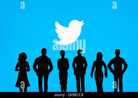 Le silhouette figurate della gente sono viste davanti al logo sfocato di Twitter in esposizione. Concetto. Stafford, Regno Unito, 26 ottobre 2022. Foto Stock