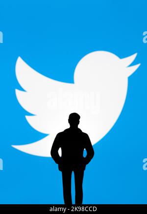 Twitter ed Elon Musk Deal Concept. La silhouette della figura è visibile di fronte al logo Twitter sfocato in esposizione. Stafford, Regno Unito, 26 ottobre 202 Foto Stock