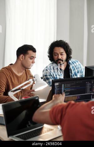 Programmatori che discutono della nuova funzionalità di rilascio sul sito Web Foto Stock