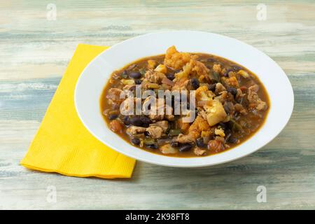 Cavolfiore di pollo e fagiolo stufato in ciotola per zuppa bianca con tovagliolo giallo Foto Stock