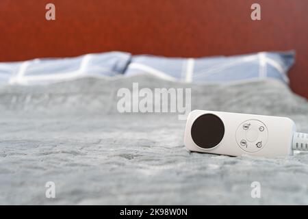 coperta elettrica con controller su un letto a composizione orizzontale Foto Stock