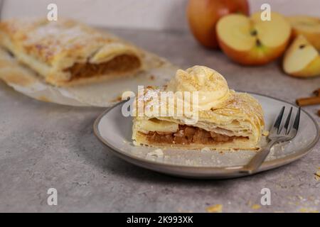 pezzo di un rotolo di strudel di mele con cannella e gelato sulla parte superiore Foto Stock