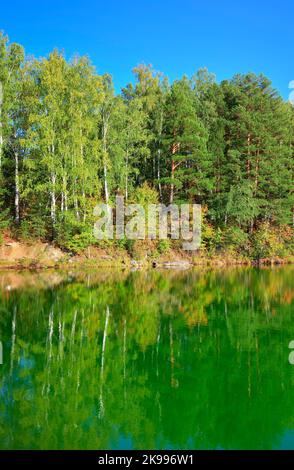 Lago Aya nelle montagne Altai. Nelle acque del lago si riflettono i pini sulle rive rocciose. Siberia, Russia, 2022 Foto Stock