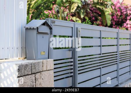 Vista della cassetta postale in metallo vicino alla recinzione all'esterno Foto Stock