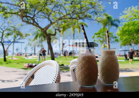 Tazze di caffè su un tavolo in una bella giornata di sole nella spianata della città di Cairns Foto Stock