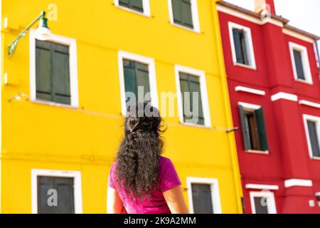 Ragazza che guarda sulle case colorate dell'Isola di Burano a Venezia Foto Stock